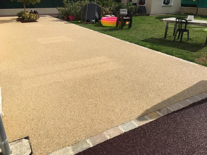 Cour en revêtement clair avec bordure en pavés